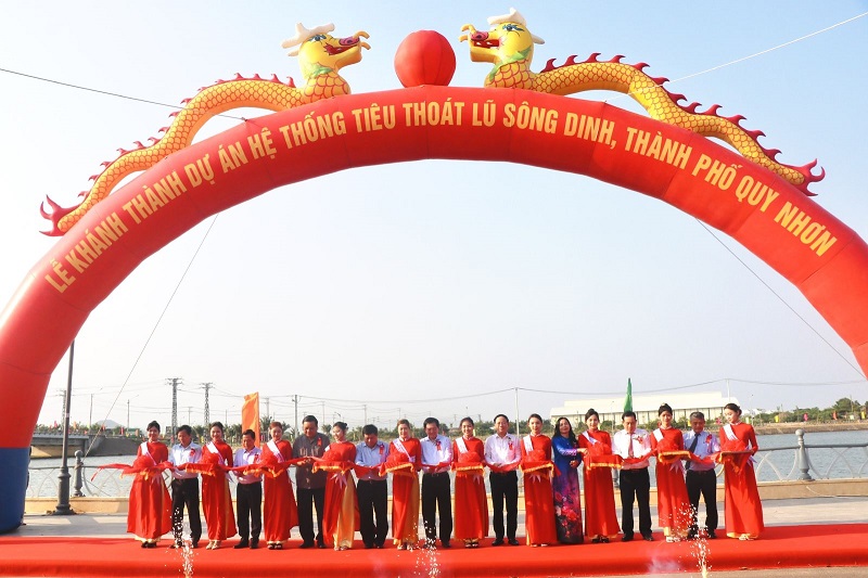 Phó Thủ tướng Chính phủ Nguyễn Chí Dũng (thứ 8 từ trái sang) cùng các đồng chí lãnh đạo tỉnh thực hiện nghi thức cắt băng khánh thành Dự án Hệ thống tiêu thoát lũ sông Dinh