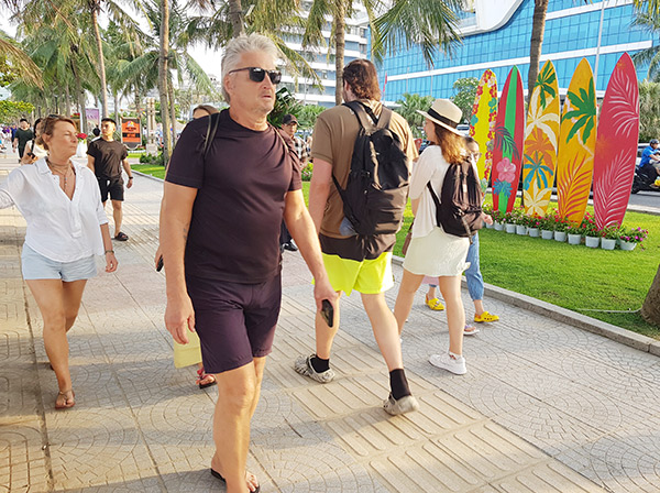 Du khách nước ngoài thưởng ngoạn đường hoa biển Đà Nẵng 2025.