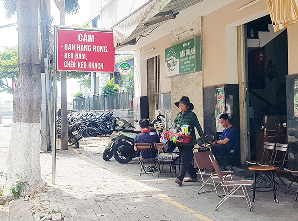 Tình trạng bán hàng rong, đeo bám, chèo kéo khách diễn ra ngay cạnh những tấm bảng cấm.