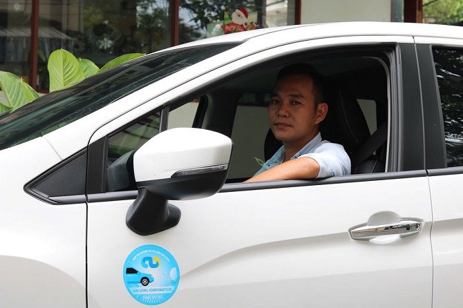 Lái xe Grab Car với phương tiện có nhận diện của Cửu Long Corporation.