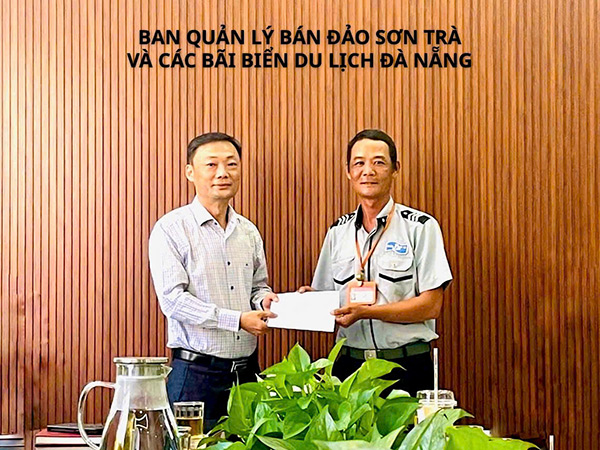 Trưởng BQL Bán đảo Sơn Trà và các bãi biển du lịch Đà Nẵng Nguyễn Đức Vũ trao khen thưởng đột xuất cho anh Phan Thanh Trinh.