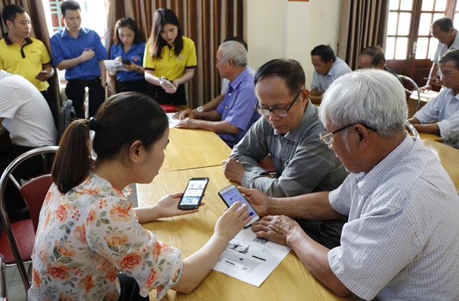 Thành viên Tổ công nghệ số cộng đồng hỗ trợ người dân cài đặt ứng dụng số và sử dụng dịch vụ công trực tuyến