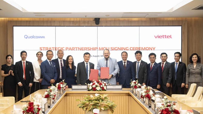 Trung tướng Tào Đức Thắng - Chủ tịch kiêm Tổng Giám đốc Tập đoàn Viettel (thứ 7 từ trái sang) và ông Cristiano Amon - Chủ tịch kiêm Tổng Giám đốc toàn cầu Tập đoàn Qualcomm trao văn bản ký kết.