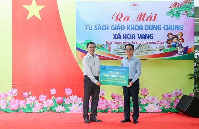 Phó Chủ tịch UBND xã Hòa Vang Hồ Tăng Phúc (bên trái) tiếp nhận biển tượng trưng tài trợ từ ông Nguyễn Văn Hội - Thành viên HĐQT BSR đại diện trao tặng