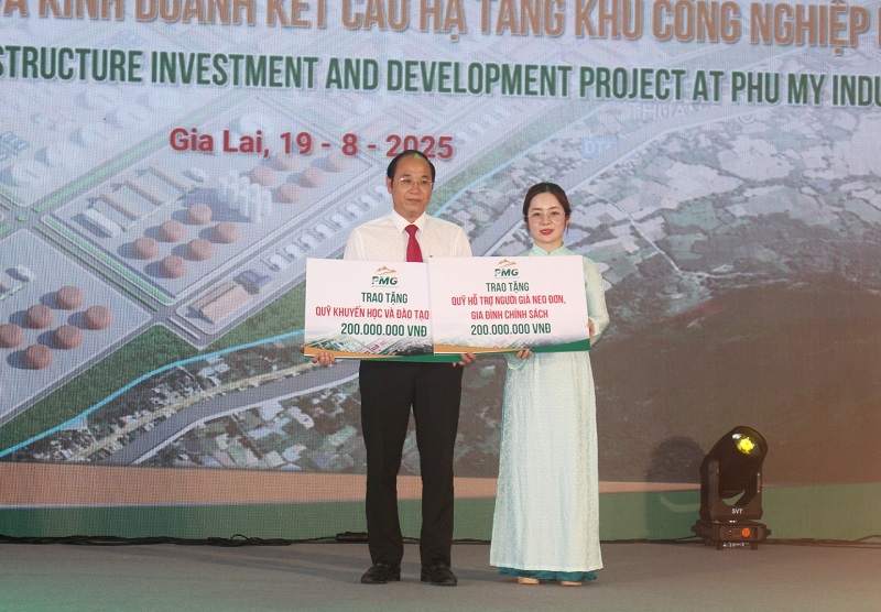 Đại diện Tập đoàn Phù Mỹ (bên phải) trao hỗ trợ cho lãnh đạo UBND xã Phù Mỹ Đông.