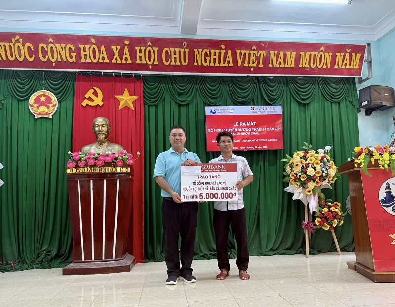 Ông Lê Thành Nam - Phó Giám đốc Agribank Chi nhánh Quy Nhơn (bên trái) trao quà cho Tổ đồng quản lý bảo vệ nguồn lợi thủy hải sản xã Nhơn Châu