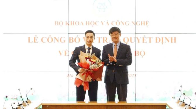 Thứ trưởng Bùi Hoàng Phương trao quyết định và tặng hoa chúc mừng ông Trần Quang Hưng. Ảnh: Trung tâm Truyền thông KH&CN