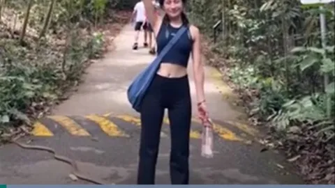 CLIP: Mải chụp ảnh, cô gái không hay biết rắn hổ chúa bò qua chân