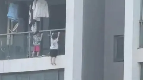 Thót tim cảnh 2 bé trai leo ban công tầng 13 làm động tác hít xà đơn